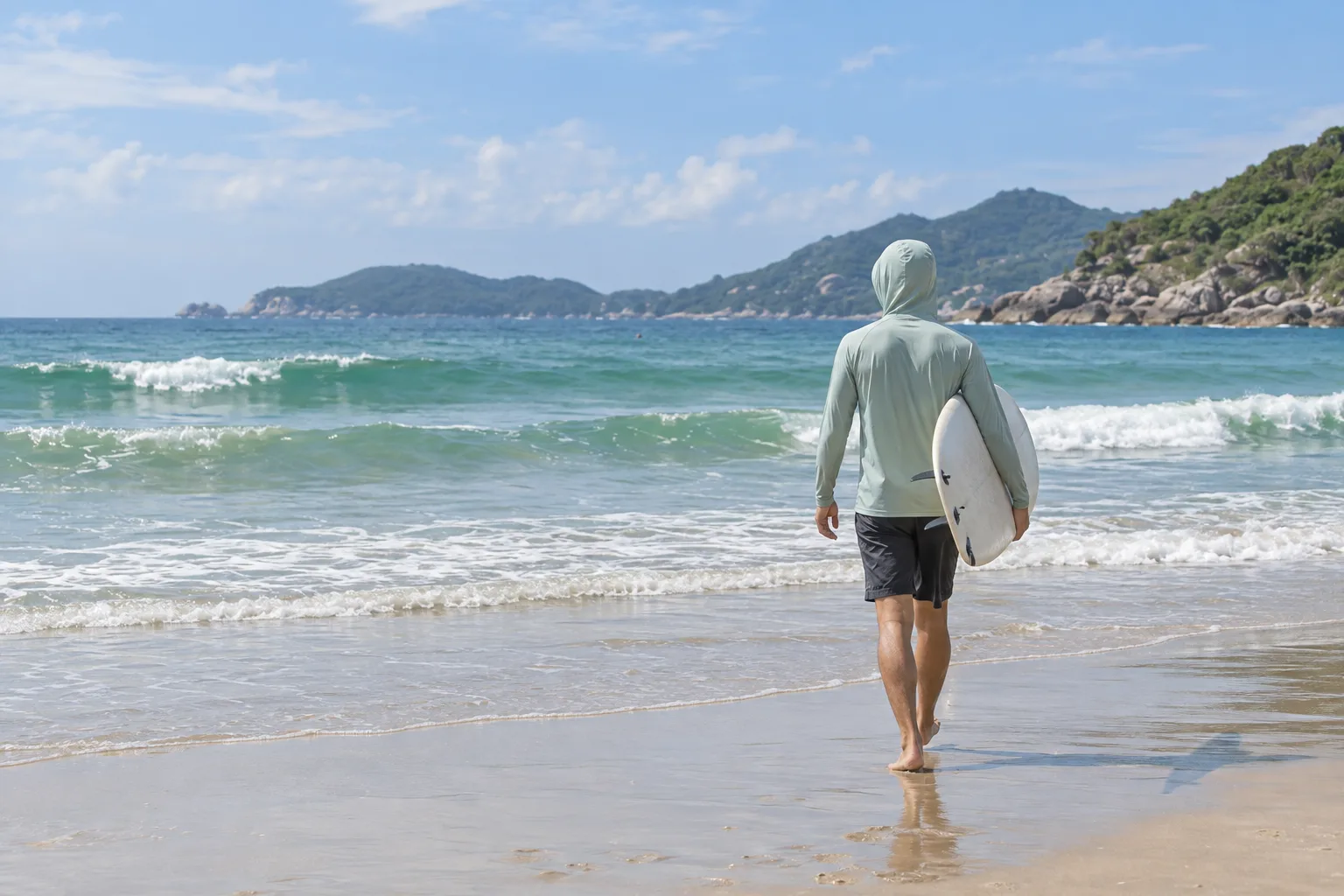 Concept image of a surfer in a lightweight rashguard on a sunny subtropical coast.